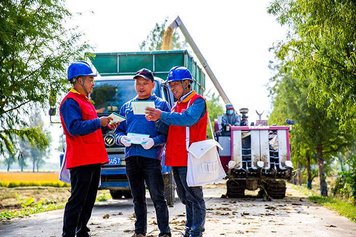 电力人员为农户介绍秋收用电安全知识