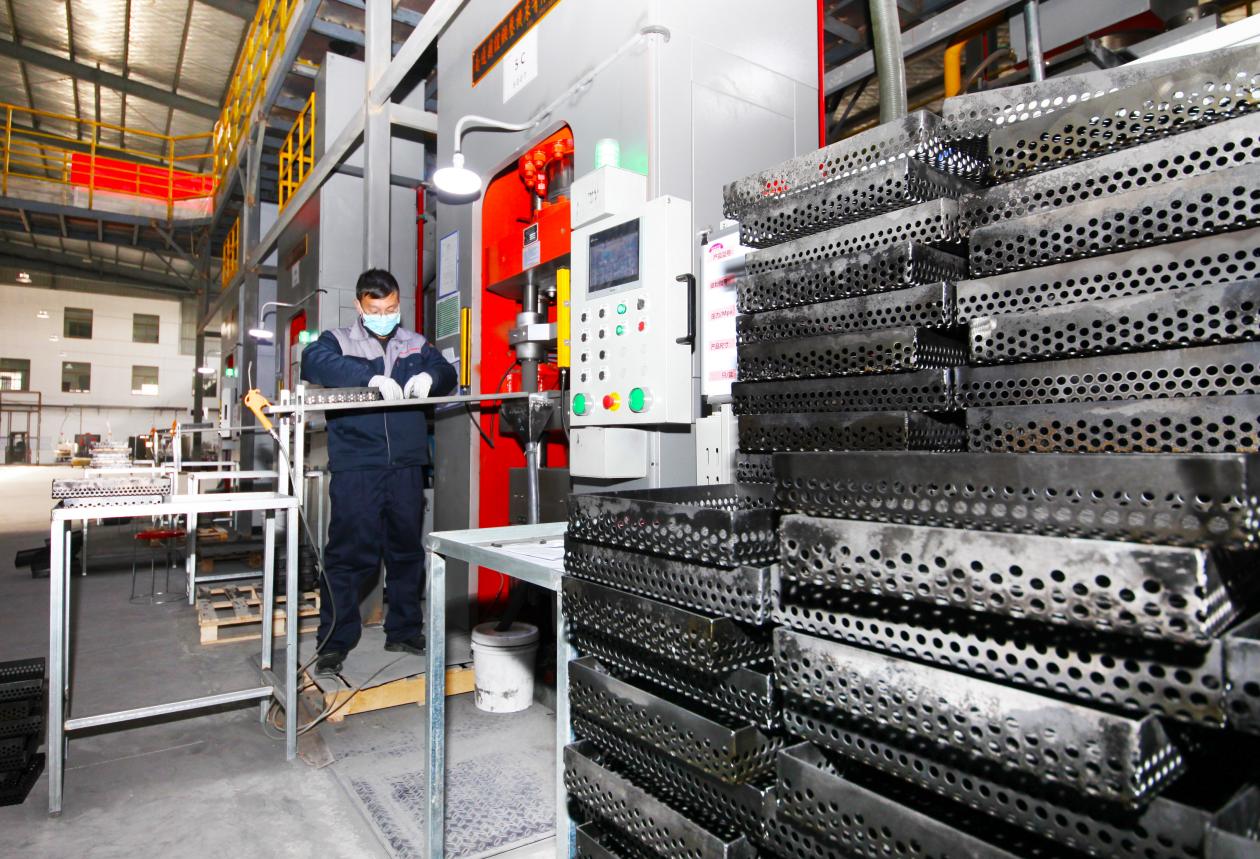 工人们忙碌的身影穿梭其间，正在生产磁芯订单产品。