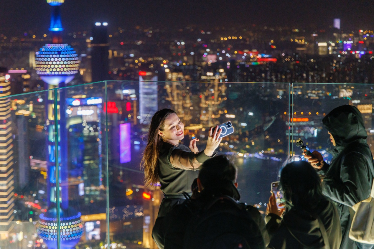 白玉兰广场观景台，游客以陆家嘴为背景拍照。人民网记者 王初摄
